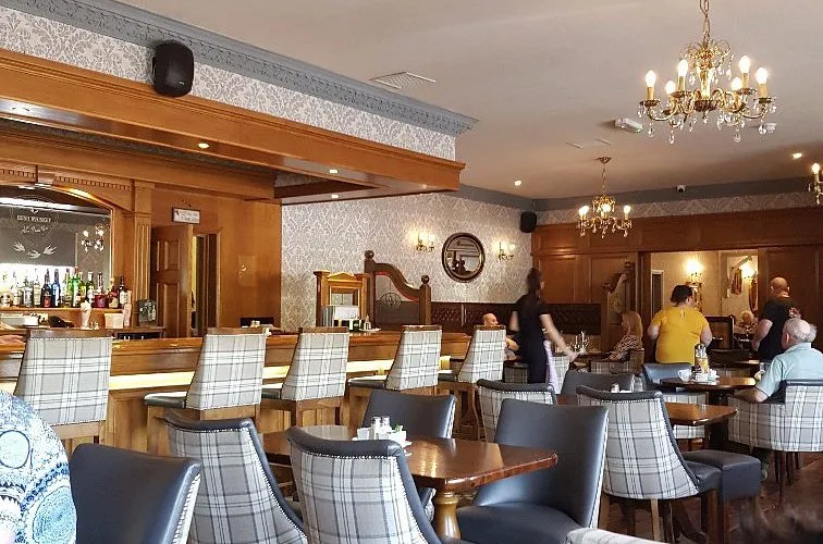 The main lounge with tartan chairs, oak bar and chandeliers
